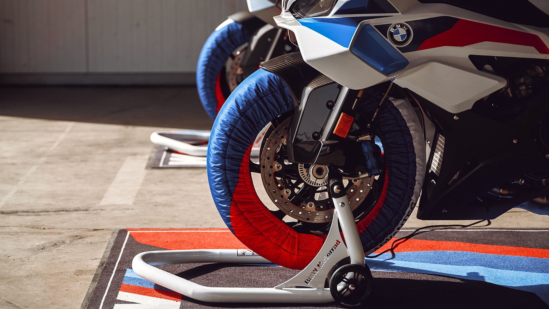 Prim plan al roții față a modelului S 1000 RR de la BMW Motorrad pe stand pentru motocicletă