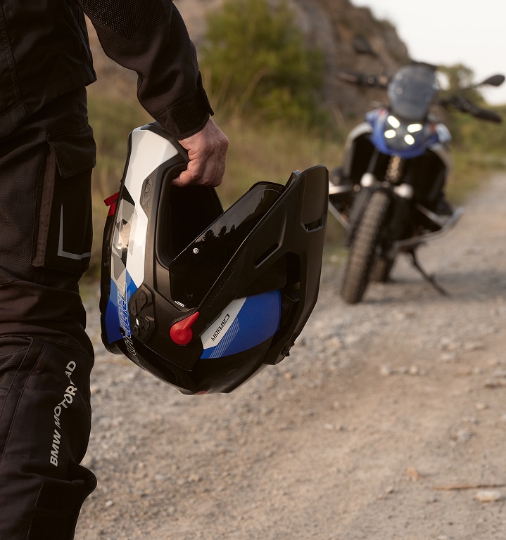 O persoană ține în mână o cască de motocicletă.